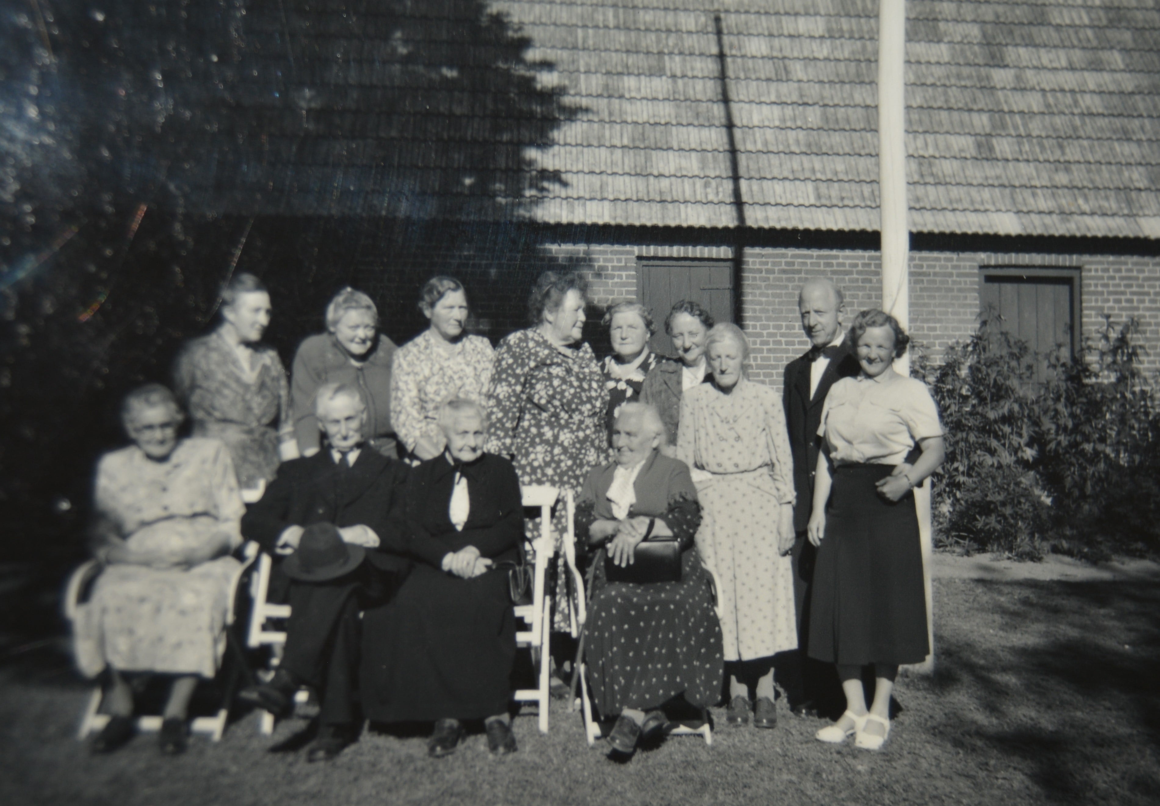 1956 Tunøs gamle i præstegårdshaven. Nr. 4 forrest Katrine Kristiansen. Foran flagstangen pastor Alfred Markvardsen og frue.